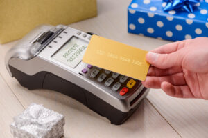 tapping a card for gifts, close-up shot, the Cons of the Credit and Debit Card Tap Feature